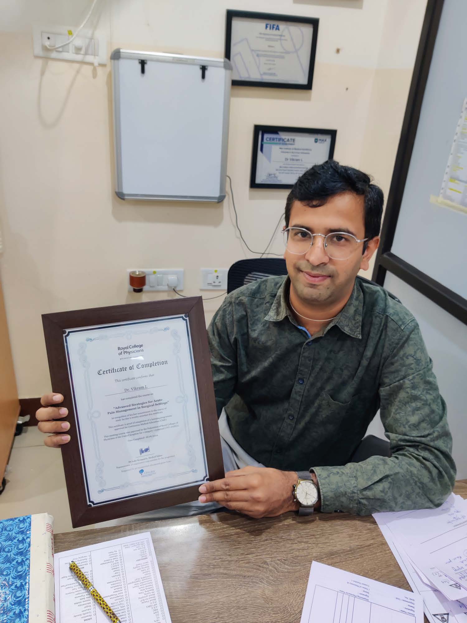 Dr. Vikram L with a professional certificate.